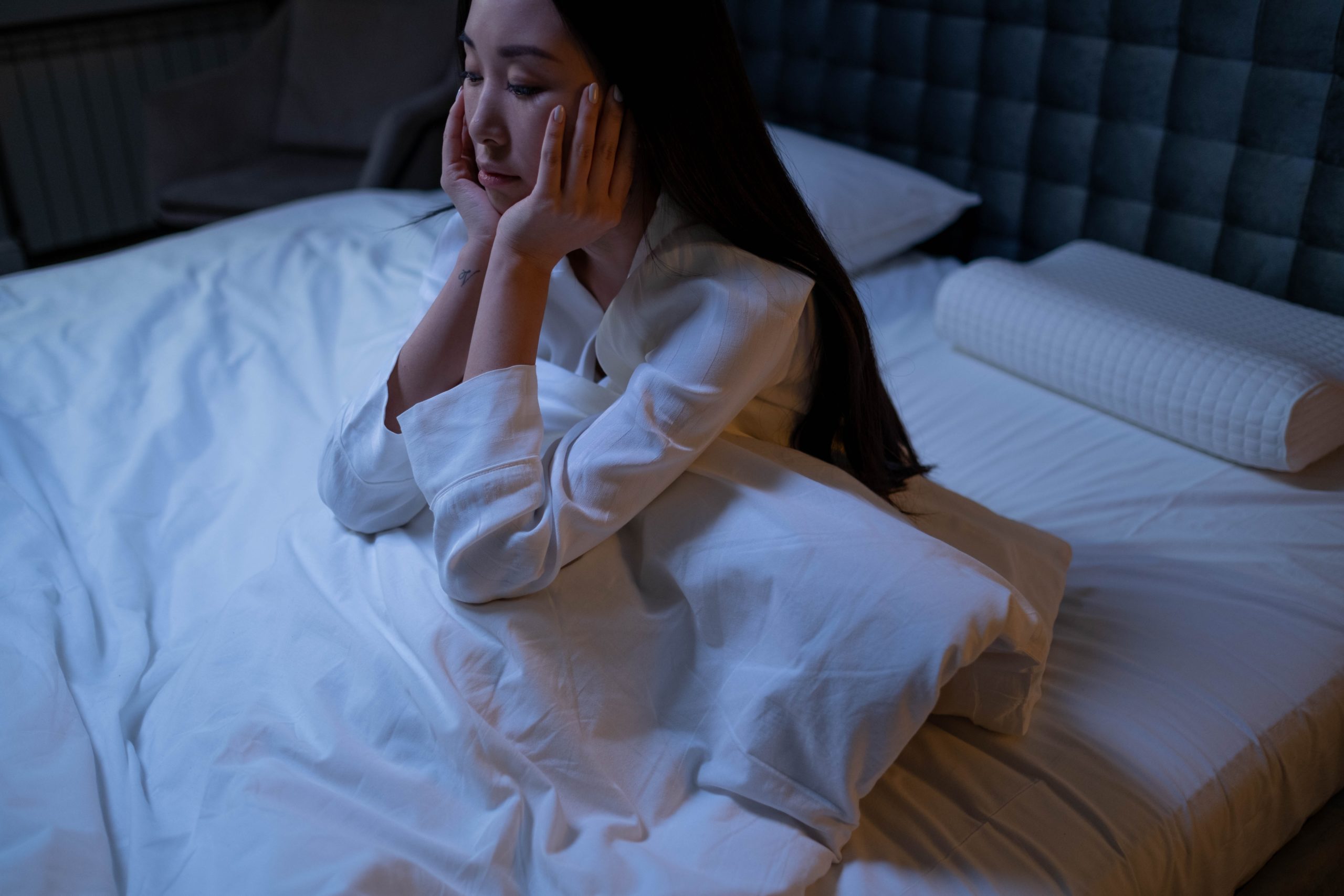 woman unable to sleep sitting up in bed