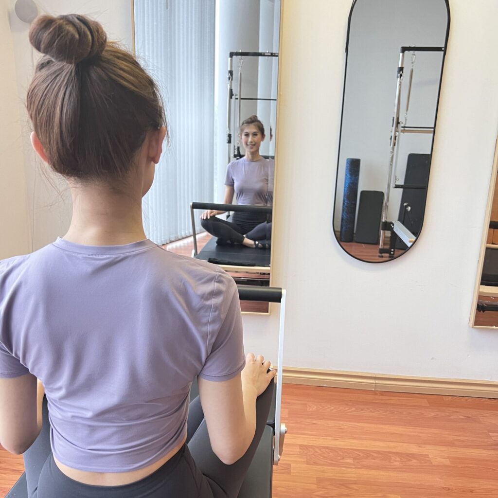 woman doing pilates lunges in front of a mirror