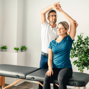 pilates instructor helping a woman side stretch her arms and core