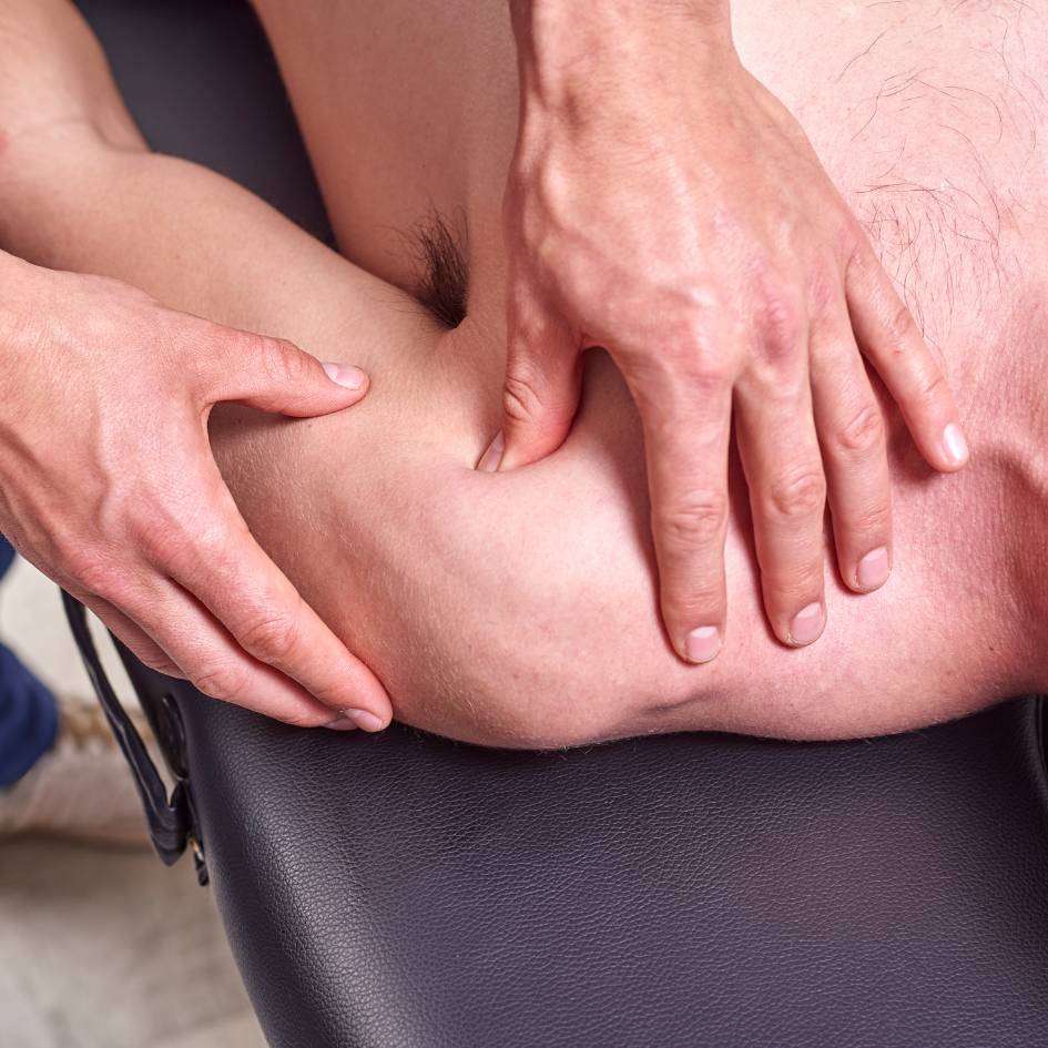 A close-up photo of a therapist's hands applying pressure to the shoulder muscle of a client during a Fascial Stretch Therapy session in Burnaby. The therapist is carefully stretching the deltoid muscle to help relieve tension and improve mobility, demonstrating the targeted and gentle techniques used in this therapy.